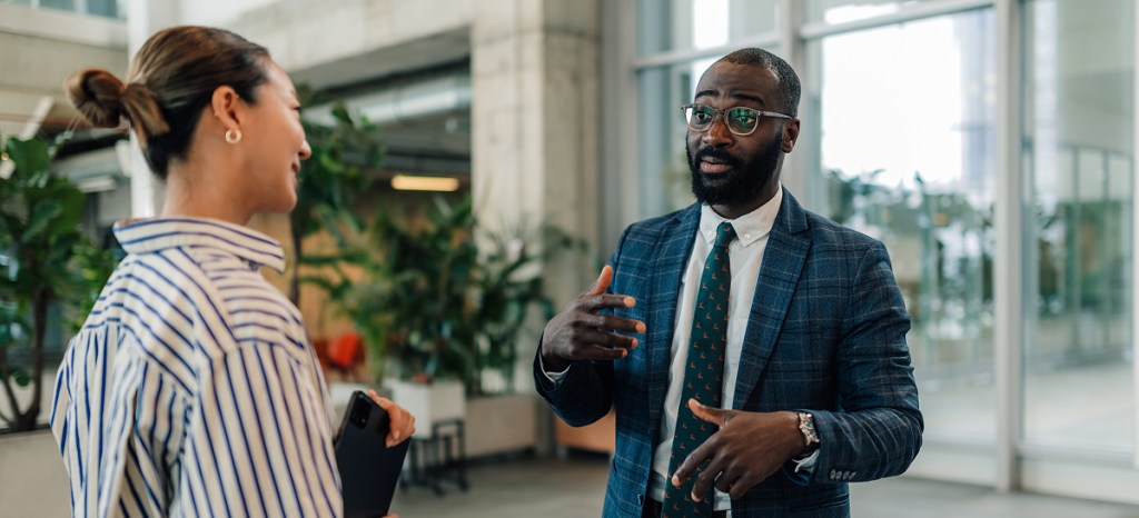 man in suit talking to professional woman